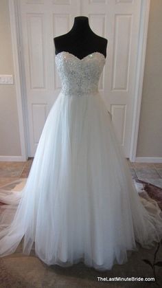 a white wedding dress on display in front of a door