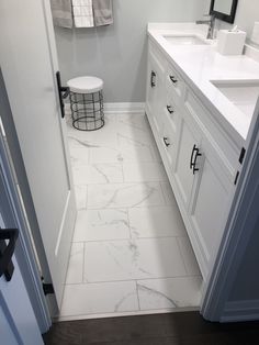 a white bathroom with marble floor and walls