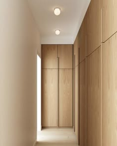 an empty hallway with wooden cabinets and white walls