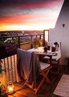 a table and chairs sitting on top of a wooden deck next to a potted plant