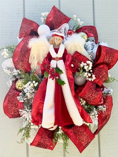 a christmas wreath with an angel doll on it