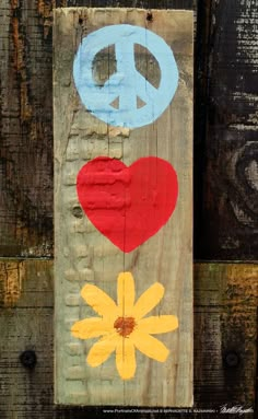 a wooden sign with peace, love and daisies painted on it