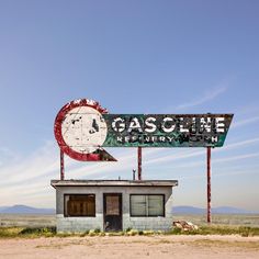 an old gas station with a large sign above it that says gasoline refinery, in the middle of nowhere