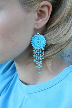 a close up of a person wearing some kind of earring with beads on it