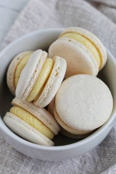 a white bowl filled with macaroons on top of a table