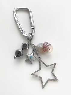 a keychain with charms attached to it on a white surface, including a star