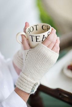 a woman holding a coffee cup with the words hot tea on it in her hands