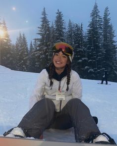 a woman sitting in the snow with her skis on