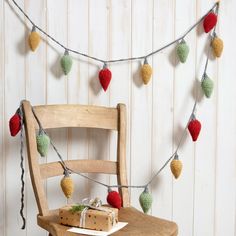 a wooden chair sitting next to a string of christmas lights