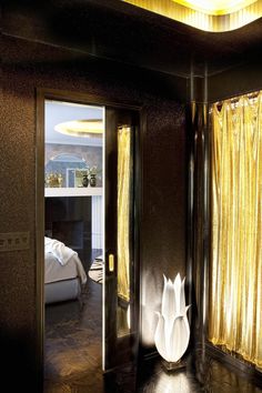 an elegant bedroom with gold drapes on the windows