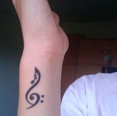 a person with a tattoo on their left wrist and the word music written in black ink