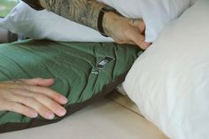 a man with tattoos on his arm is holding onto a pillow