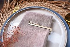 a plate with a nameplate on it sitting next to a fork and spoons