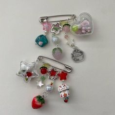 a bunch of charms sitting on top of a white table next to an apple and other items