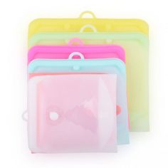 four different colored plastic bags with handles on each side and one has a bow at the top