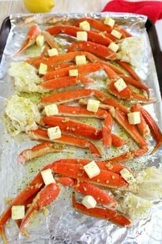 cooked lobsters on aluminum foil with lemon wedges and parmesan croutons