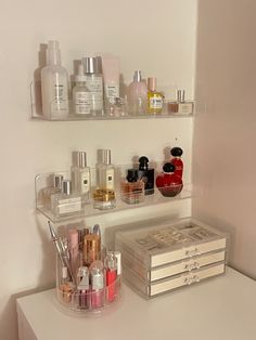 a white counter topped with lots of different types of cosmetics and perfume bottles next to each other