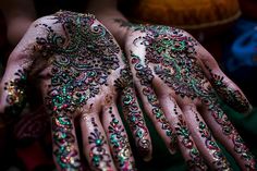 two hands covered in henna and jewels