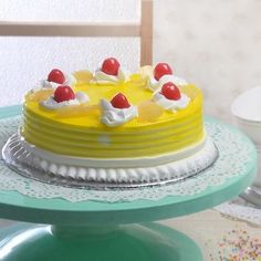 a yellow cake sitting on top of a table next to a plate with sprinkles