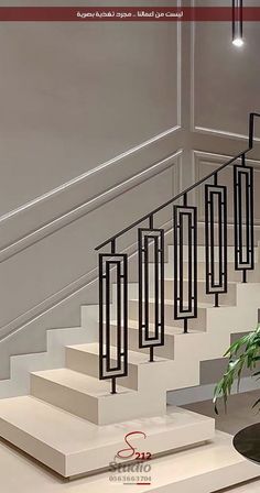 a plant sitting on top of a white table next to a stair case with black railings