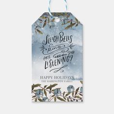 a blue watercolor christmas gift tag with holly branches