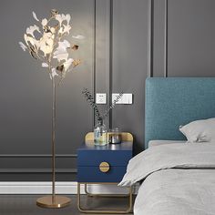 a bedroom with a bed, nightstand and flowers on the night stand next to it