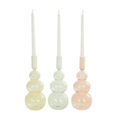 three candles sitting next to each other in different colors