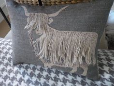 a decorative pillow with a long horned animal on it's side sitting on a couch