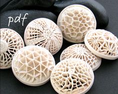 five white carved buttons sitting on top of a black cloth