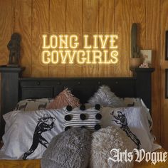 there is a bed with pillows on it and the words long live cowgirls