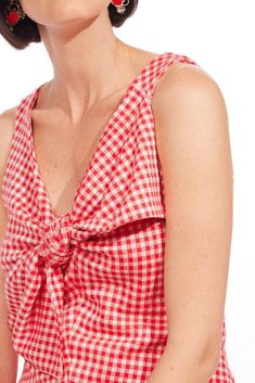 Take your summer barbeque to the next level with our pink gingham plaid Gidget Top. Featuring an oversized bow detail and a V-neckline, this top is perfect to wear with your favorite jeans for a relaxed, fun look. Oversized bow Pullover styling Sleeveless Hand wash Polyester, Rayon, Spandex Lining Polyester Dimensions23.5"L Gingham V-neck Top For Day Out, Chic Gingham Tops For The Beach, Plaid Summer Tops For Day Out, Summer Plaid Tops For Day Out, Cotton V-neck Tops For Picnic, Plaid Tops For Summer Day Out, Trendy Plaid Tops For Picnic, Spring Gingham V-neck Top, Summer Gingham Tops With Tie Straps