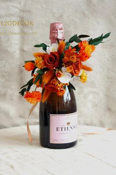 a bottle filled with flowers sitting on top of a table