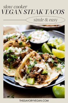 slow cooker vegan steak tacos on a plate with limes and sour cream