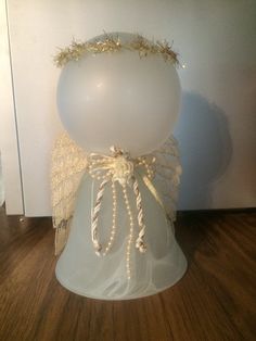 a white balloon with gold decorations on it's head is sitting on a table