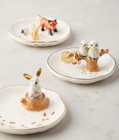 three small white plates with animals on them