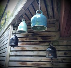 three bells hanging from the side of a building