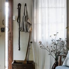 a room with a chair, coat rack and flowers in it