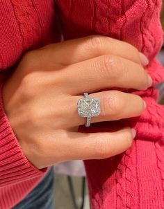 a woman wearing a diamond ring on her finger