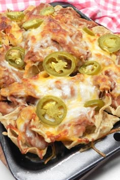 a cheesy pizza with green peppers and cheese on it sitting on a pan