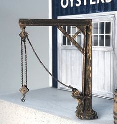 a scale model of an old fashioned bridge with chains on the front and side, in front of a store window