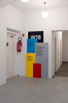 an empty room with three different signs on the wall and two red fire extinguishers