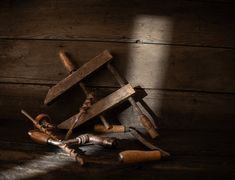 an assortment of tools sitting on top of a wooden floor next to a hammer and wrench