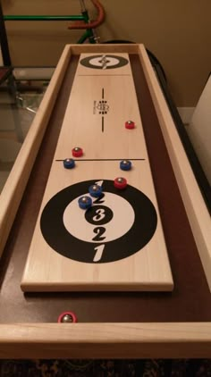 a close up of a table top with a bowling ball on it and two pins in the middle