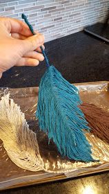 a person holding a blue and brown feather on top of a metal pan