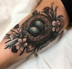 a bird's nest with three eggs in the middle of it and flowers around