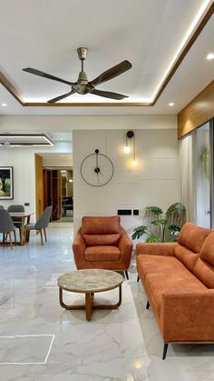 a living room filled with furniture and a ceiling fan