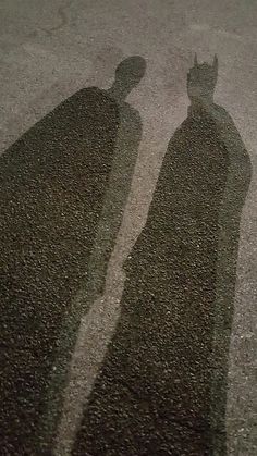 the shadow of two people standing next to each other with their shadows on the ground