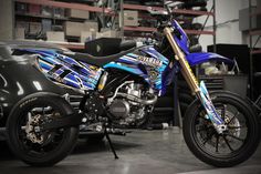 a blue and black motorcycle parked in a garage