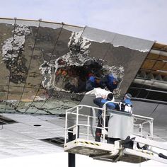 workers are working on the side of a building that has been torn down and is being repaired