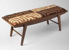 a wooden bench with an upholstered seat cushion on it's sides and legs